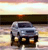 A pixelated image of a silver car with dark windows and headlights, positioned on a road under a gradient sky transitioning from light to dark tones.