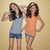Two pixelated figures stand side-by-side against a beige background, one in light blue sleeveless top and dark shorts, the other in orange sleeveless top and dark shorts.