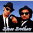 Two pixelated figures in black suits and white shirts stand against a blue background, one wearing a black fedora and both wearing dark sunglasses.