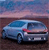 Pixelated image of a light blue sedan on a brown surface under a gradient sky with pink and blue hues.