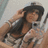 A pixelated image of a person with long dark hair wearing a light-colored top, positioned next to a black background with white text reading 'nicole' and a small heart symbol.