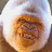 A pixelated animated buddy icon featuring a circular face with brown and orange tones on the left, next to white text reading "Smile!" on a solid brown background.
