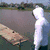 A person in a white hoodie walks along a narrow path over water, with the word "woof!" appearing on screen.