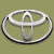 Static pixelated icon of a silver Toyota logo on an olive-green background with visible anti-aliasing and dithering effects.