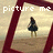 Pixelated image of a figure in dark clothing standing on a beach with text above reading 'picture me' and 'pretty'