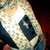 A pixelated image of a character with light-colored hair and dark clothing, viewed from an angle against a red background.