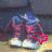 A pixelated figure in blue and pink clothing stands on a light surface with changing colored shapes near its feet.