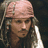 A pixelated image of a person with long hair and a bandana, wearing a white shirt against a dark background.