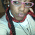 A person with braided hair wears pink glasses and a white shirt with red trim, shown in three where the head position shifts slightly left to right