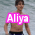 A shirtless person in dark swim trunks stands in water with text overlays reading "Aliya," "bieber," and "is here" in distinct colors and styles.