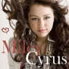 A static image of a person with long brown hair, wearing a patterned shirt, with text overlays reading 'Miley' and 'Cyrus' and a small red heart symbol.