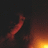 Pixelated image with dark background showing red and orange light effects, yellow text reading "Lights flicker off my skin..." and "Allowing me to live my own life." on black