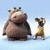 Pixelated static image shows two cartoon characters: a large brown bear-like figure and a smaller giraffe standing side-by-side against light blue background.