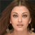 Pixelated close-up of a person with long brown hair, wearing large dark earrings with light accents, against a dark background.