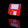 Red and white square-shaped icon with a white rectangle and smaller white square on its face, rotating against a black background.