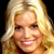 Static pixelated portrait of a smiling person with long blonde hair against dark background, rendered in low-resolution 256x256 pixels.