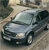 Static pixelated image of a silver sedan viewed from a high angle, positioned on a textured surface with blurred background elements.