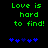 Green pixelated text 'Love is hard to find!' on black background with blue heart symbols below, two variations of heart positions visible.