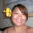 A pixelated static image shows a person with short brown hair wearing a yellow flower accessory on the left side of their head, set against a blurred background.