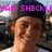 A pixelated image of a person wearing a dark cap and white shirt with pink text above the head.