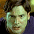 A pixelated contact sheet showing two frames of an animated icon with a person's face on the left and green text reading "Original Icons .com" on the right against a dark background.