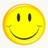 A static yellow circular icon with a simple black smiley face, featuring two vertical oval eyes and a curved mouth, set against a light background.