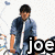A pixelated image of a person in a blue denim shirt and light pants holding bicycle handlebars, with text overlays reading 'joe', 'is', and 'HOT' across different frames.