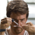 A pixelated close-up of two people in a physical interaction, one person's arm is raised near the other's face.