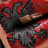 Pixelated static image of a figure with dark hair and red accents against a red background, showing partial facial features and clothing details.