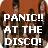 Pixelated static image with bold white text reading "PANIC!! AT THE DISCO!" overlaid on a blurred background of indistinct figures and warm tones.