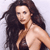 A pixelated image of a person with long dark hair, bare shoulders, and a light skin tone against a pale background.
