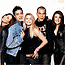 Group of people in casual poses with varied clothing and expressions, including a person holding their hand near the face.