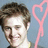 A pixelated image shows a person with short brown hair on the left, next to a pink heart-shaped object and yellow text on a bright pink background.