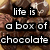 Pixelated image of chocolate candies with overlaid text reading "life is a box of chocolate you never know what your gonna get" in white block letters on black rectangles.