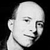 Pixelated grayscale portrait of a bald person with a neutral expression, cropped to show head and upper neck against a solid black background.
