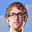 Pixelated static image of a person's face with light brown hair and glasses against a blue background, rendered in low-resolution 256x256 pixels.