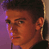 Pixelated static image of a person's face in profile view with warm orange and purple tones, cropped to show only the head and shoulders against a gradient background.