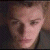 A pixelated image split into two sections: a person's face on the left and green text on a dark background on the right.