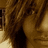 A static pixelated image shows a partial view of a figure with brown hair and light skin tones against a dark background.