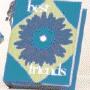 Blue book with yellow diamond shape containing dark blue flower, white text 'best friends' below; adjacent lamp with striped shade and decorative base.