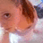 Pixelated close-up of a person's face with brown hair, light skin, and visible eye details against a blurred background.
