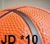 Pixelated static image with orange and brown tones showing partial text 'JD * 10' at the bottom against a blurred background.
