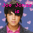 Pixelated image of a person with dark hair wearing a pink shirt and dark jacket against blue background with light purple shapes.