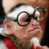 Pixelated static image of a cartoon character with glasses and red clothing against dark background.