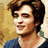 A pixelated image of two people with brown hair, one wearing a dark blue shirt against a light background.