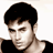 Pixelated static image of a person with short dark hair wearing a black top against a white background, rendered in low-resolution 256x256 pixels.