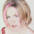 A pixelated image of a person with light brown hair and pink highlights, wearing a red strap top against a white background.
