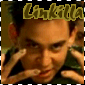 A person with short dark hair holds both hands near their face, wearing a green shirt under a brown jacket. The text 'Linkilla' appears above in stylized yellow letters.