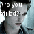 A pixelated split-screen image shows a person with dark hair and a collared shirt, with text reading 'Are you afraid?' on the left side.