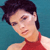 Pixelated image of a person with short dark hair wearing a red sleeveless top against a teal background.
